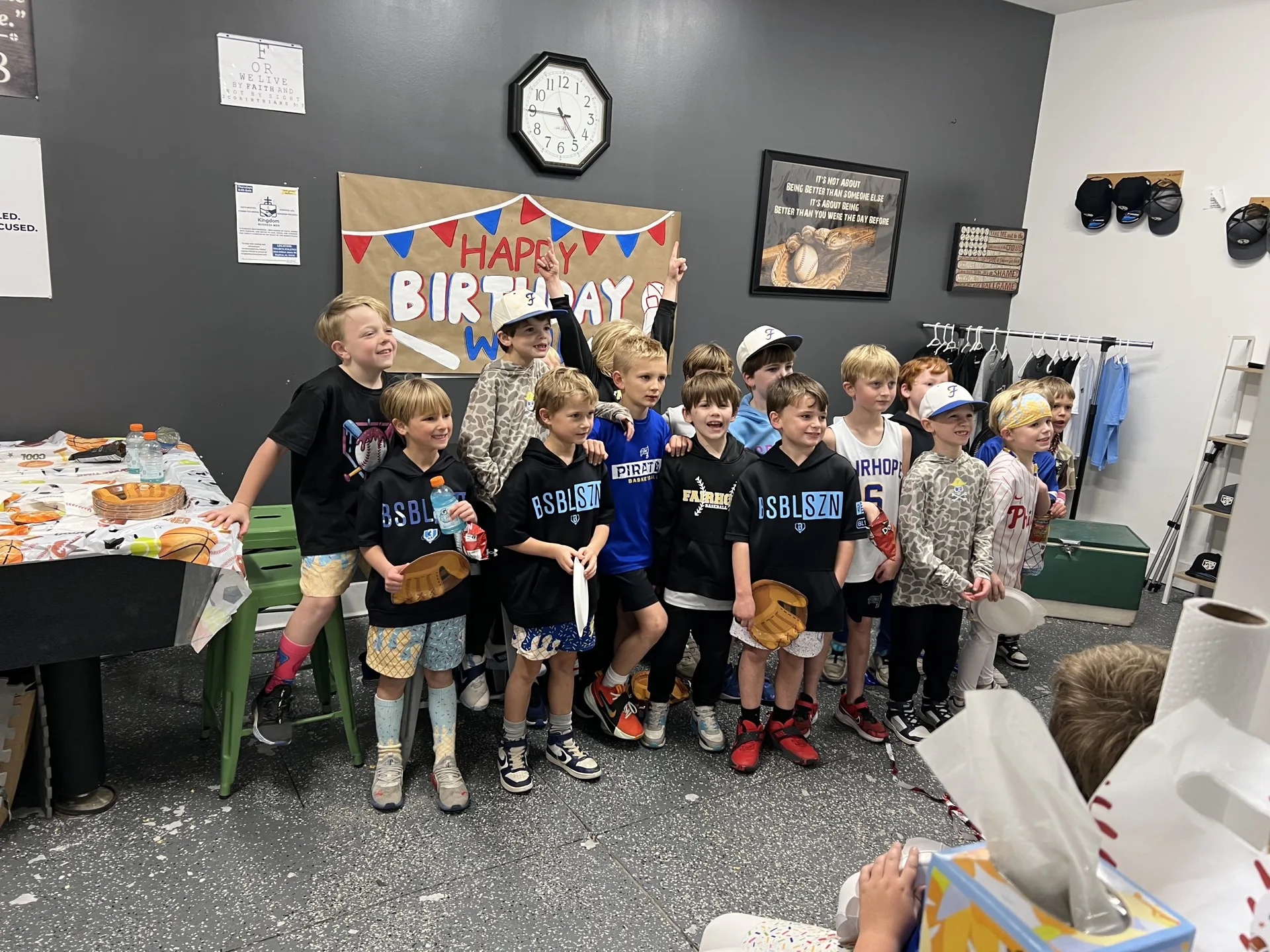 Group of kids posing together under a 'Happy Birthday' banner