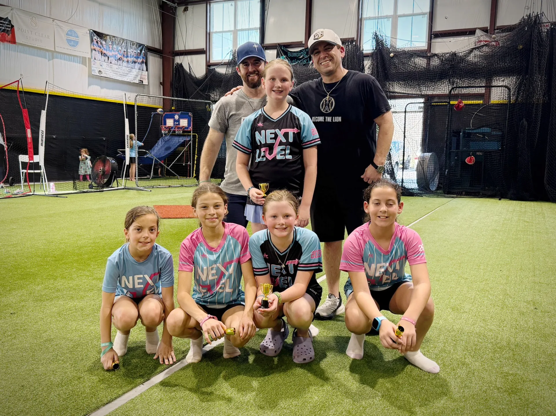 Softball team and coaches posing for a group photo at a birthday party