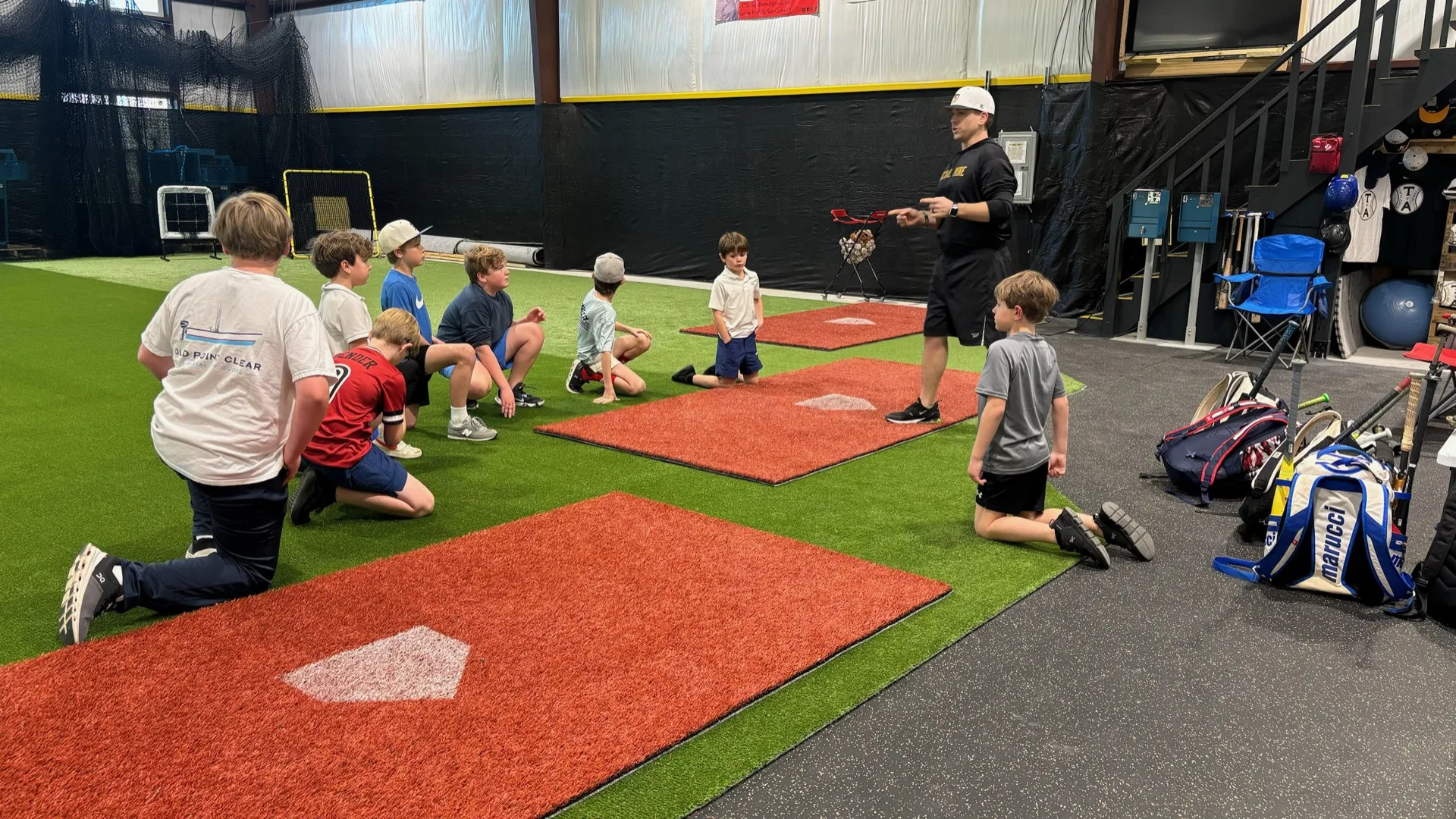 Kids seated and listening to a coach during a group coaching session