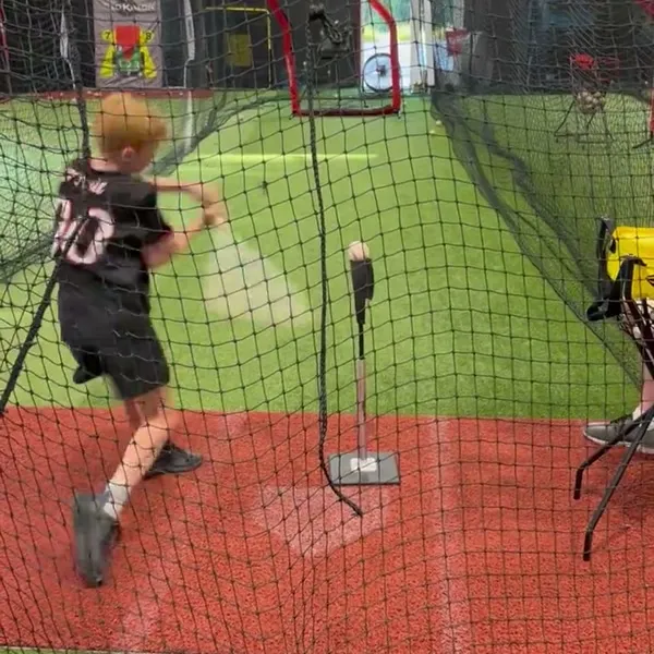 Young kid practicing hitting from the tee
