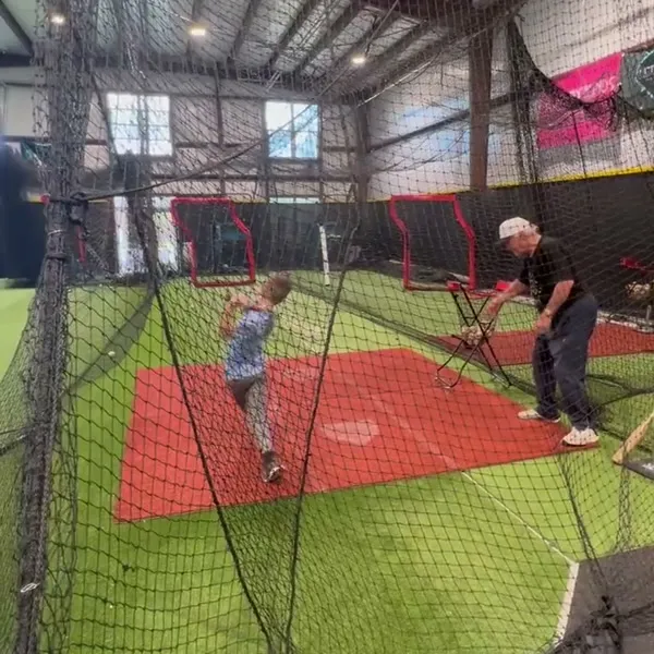 Young kid taking swings in the batting cage