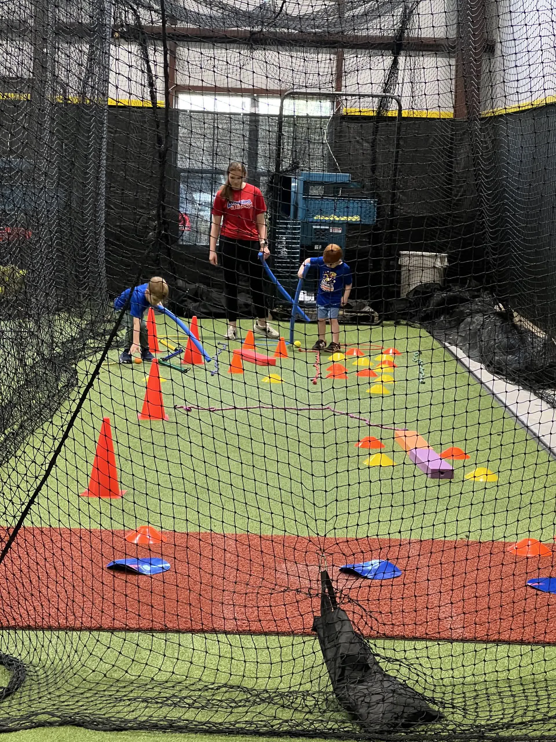 Kids running a cone drill during an indoor soccer session at Taylor'd Athletics