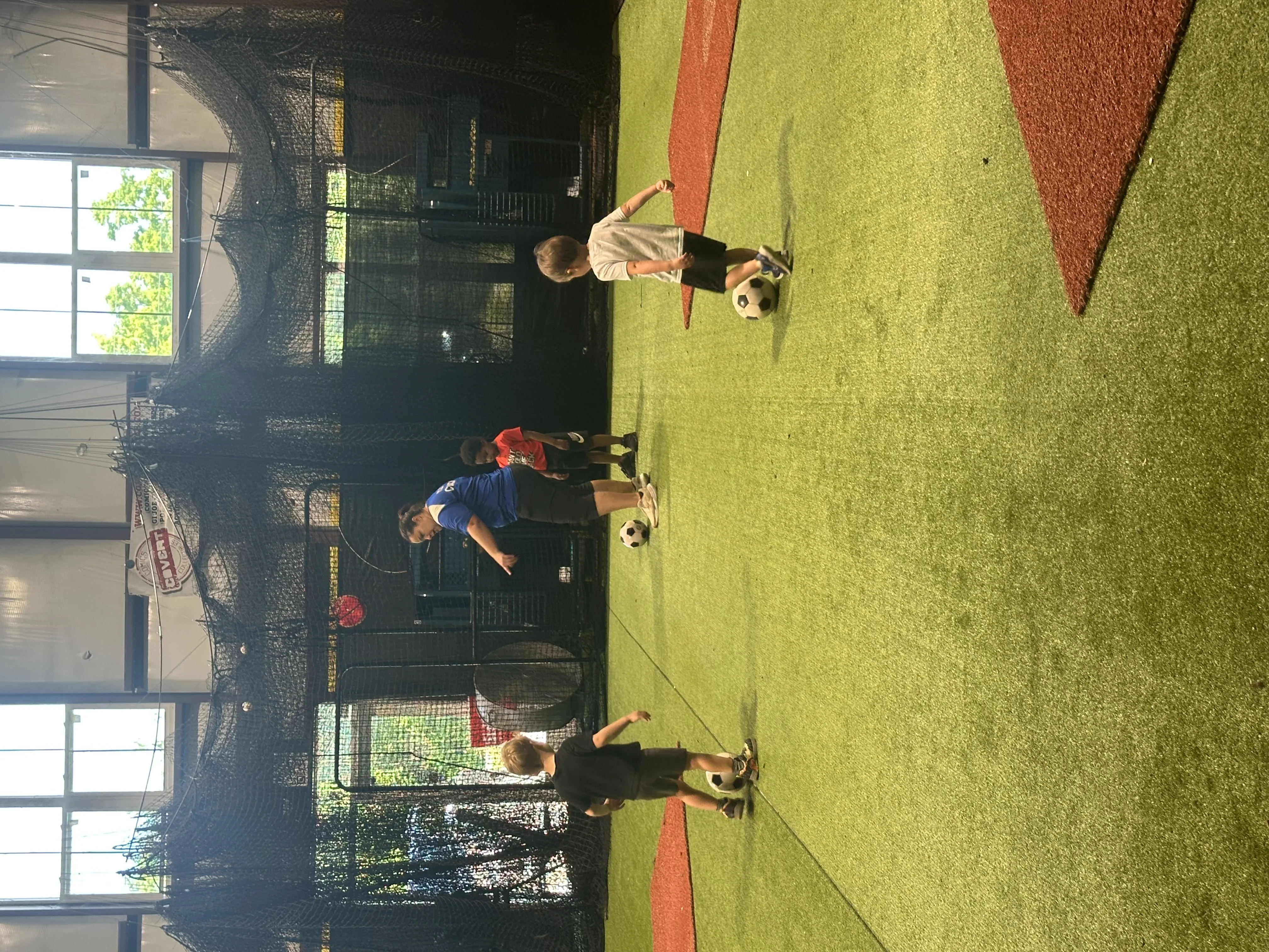 Kids doing soccer ball drills on the turf at Taylor'd Athletics